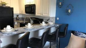 a kitchen with a counter with chairs and a sink at Hollywood Studio with Pool, Parking and Gym in Los Angeles +15 photos