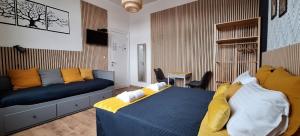 a bedroom with a blue bed with yellow pillows at Le Jardin d'Anna - Pairi Daiza à 5km Proche Shape NATO in Chièvres