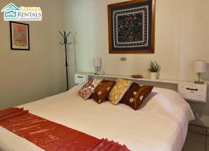 Un dormitorio con una cama con almohadas encima. en Cozy Apartment Downtown, en Nicoya