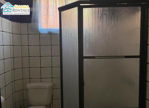 a bathroom with a toilet and a glass shower door at Cozy Apartment Downtown in Nicoya +10 photos