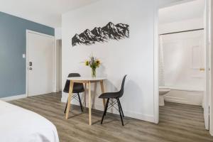 a bedroom with a table and chairs in a room at Gateway Suites Cozy stay to explore Banff and Canmore in Canmore