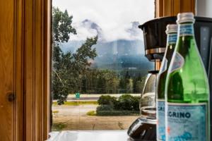 a bottle of wine sitting on a counter next to a window at Gateway Suites Cozy stay to explore Banff and Canmore in Canmore +14 photos