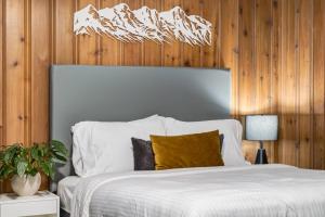 a bedroom with a white bed with wood paneling at Gateway Suites Near Canmore and Banff in Canmore