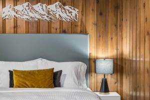 a bedroom with a bed and a lamp and wooden walls at Gateway Suites Near Canmore and Banff in Canmore
