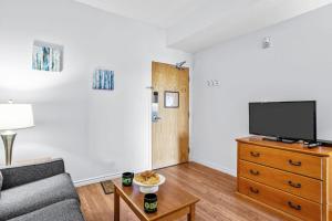 Una televisión o centro de entretenimiento en Stylish 1BR Haven in CanmoreDT near Banff Sleeps 4 7 fotos más