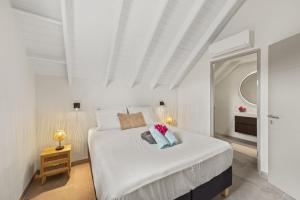 a white bedroom with a large bed and a mirror at Villa Jamzmyn 45, Relaxen met prive plunge pool in Blue Bay +41 photos