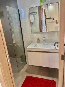 a bathroom with a sink and a shower with a mirror at LUXES Studio in Dakar