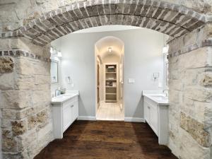 ein Badezimmer mit 2 Waschbecken und einer Steinmauer in der Unterkunft Luxury Spanish Style Getaway in Houston + 92 Fotos