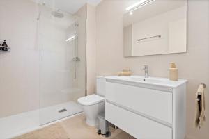 Un baño blanco con lavabo e inodoro. en Sea View Apartment Estepona - Célere Sea Views, en Estepona