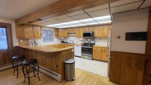 a large kitchen with wooden cabinets and stools in it at Frontier Lux 2 Bedroom in Hamilton Acres