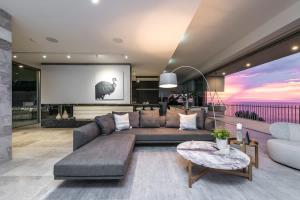 a living room with a couch and a screen at One Eighty Marino in Marino