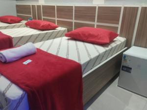 two twin beds with red pillows in a room at Hotel Progresso Itaquera - Próximo Arena Corinthians in São Paulo +15 photos