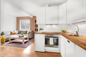 eine Küche mit weißen Schränken und ein Wohnzimmer in der Unterkunft Central and modern studio - close to everything in Guleng + 5 Fotos