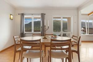 a dining room with a table and chairs and windows at Roestbakken Horizon in Guleng