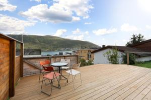 a patio with a table and chairs on a deck at Roestbakken Horizon in Guleng
