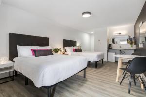 a bedroom with two beds and a desk and a kitchen at Gateway Suites Charming Stay perfect for 4 Guests in Canmore
