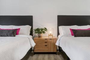 a bedroom with two beds and a night stand with a plant at Gateway Suites Charming Stay perfect for 4 Guests in Canmore