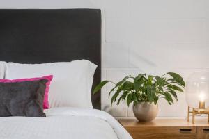 a bedroom with a white bed and a potted plant at Gateway Suites Charming Stay perfect for 4 Guests in Canmore +20 photos