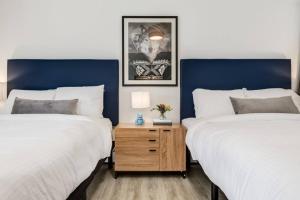 two beds in a bedroom with blue and white walls at Gateway Suites Perfect Escape to explore Banff in Canmore