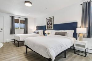 a bedroom with two beds and a blue wall at Gateway Suites Perfect Escape to explore Banff in Canmore