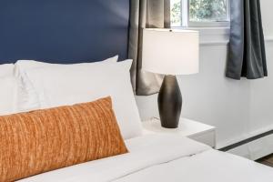 a white bed with a lamp on a side table at Gateway Suites Lovely views near Banff in Canmore