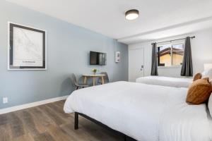 a bedroom with two beds and a table at Gateway Suites Lovely views near Banff in Canmore +16 photos