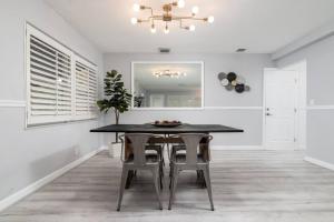 a dining room with a black table and chairs at The Residences at Lake Ridge Apt 1 in Fort Lauderdale