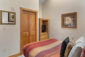 a bedroom with a bed and a wooden cabinet at Red Hawk Lodge 2312 by Summit County Mountain Retreats in Snake River Health Services Incorporated Heliport +20 photos