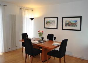 una sala da pranzo con tavolo in legno e sedie nere di Dreamhouse Apartments Edinburgh Holyrood Park a Edimburgo