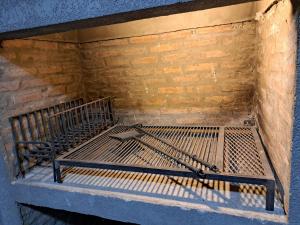 a metal bed sitting in a corner of a brick wall at Cabañas Las Mercedes in Médano de Oro