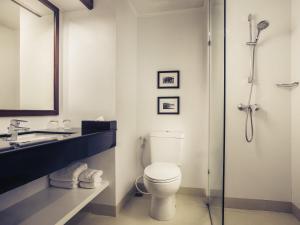 a bathroom with a toilet and a sink and a shower at Mercure Chiang Mai in Chiang Mai