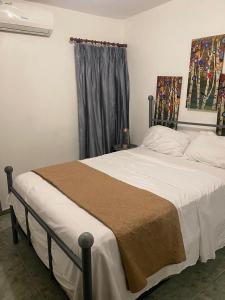 Un dormitorio con una cama con sábanas blancas y una ventana. en Recidencial sharael house, en San Isidro