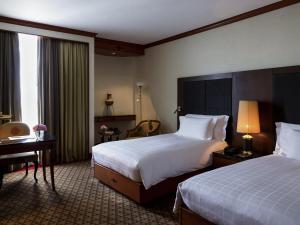 Una habitación de hotel con dos camas y un escritorio. en Pullman Khon Kaen Raja Orchid, en Khon Kaen 110 fotos más