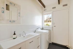 un bagno bianco con lavandino e WC di Honeysuckle Beach Haven a Cowes Altre 6 foto