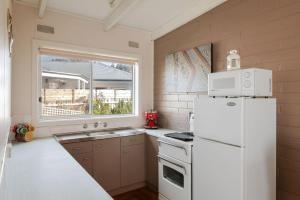 una cucina con un frigorifero bianco e un lavello di Honeysuckle Beach Haven a Cowes