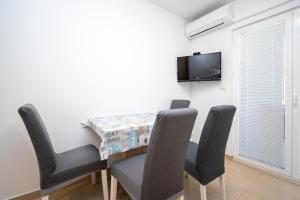 a dining room with a table and chairs and a tv at Apartments with parking space Vrsi, Zadar - 15944 in Vrsi