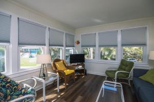 a living room with a couch and chairs and windows at Rich Tymes in Edisto Island