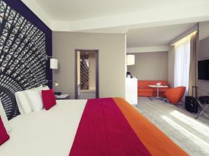 a hotel room with a large bed and a desk at Mercure Nantes Centre Grand Hotel in Nantes +52 photos
