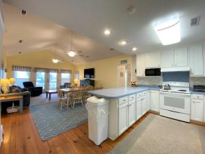 eine Küche mit weißen Schränken und ein Wohnzimmer in der Unterkunft Petty House in Edisto Island