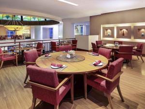 a dining room with a table and chairs at Mercure Jakarta Kota in Jakarta