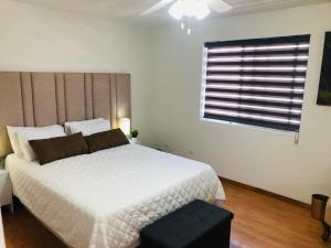 a bedroom with a large white bed and a window at Casa Encanto Ensenada Three Bed Two Bath in Ensenada