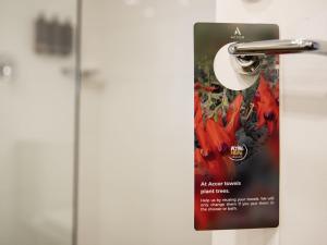 Un cartel en una puerta con una flor roja. en Mercure Sydney Parramatta, en Sídney 45 fotos más