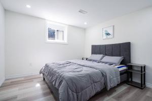 ein Schlafzimmer mit einem großen Bett und zwei Bildern an der Wand in der Unterkunft Bright & Cozy Home in the GTA (Basement Apartment) in Whitby
