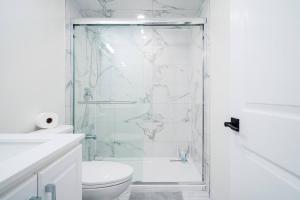 ein weißes Badezimmer mit Dusche und Toilette in der Unterkunft Bright & Cozy Home in the GTA (Basement Apartment) in Whitby + 31 Fotos
