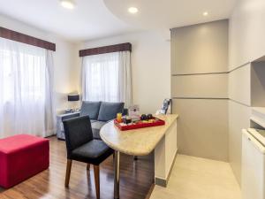 サンパウロにあるMercure Sao Paulo JKのテーブルと椅子とソファのあるリビングルーム
