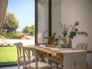 a dining room table with chairs and a table with plants on it at Secluded Villa with Panoramic Sea View in Rhodes Town +15 photos