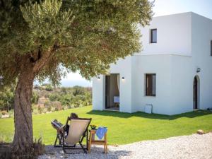 a white house with two chairs and a tree at Secluded Villa with Panoramic Sea View in Rhodes Town
