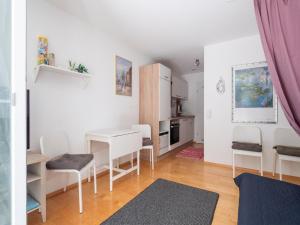 Una sala de estar con mesa y sillas y una cocina. en Cozy Retreat in Rottweil with Terrace, en Rottenmünster