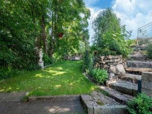 Un jardín con escaleras y un muro de piedra y césped. en Cozy Retreat in Rottweil with Terrace, en Rottenmünster