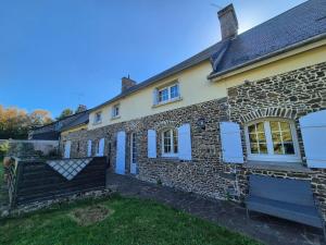 een stenen huis met blauwe deuren en een tuin bij Spacious Family Home Near the Sea in Denneville